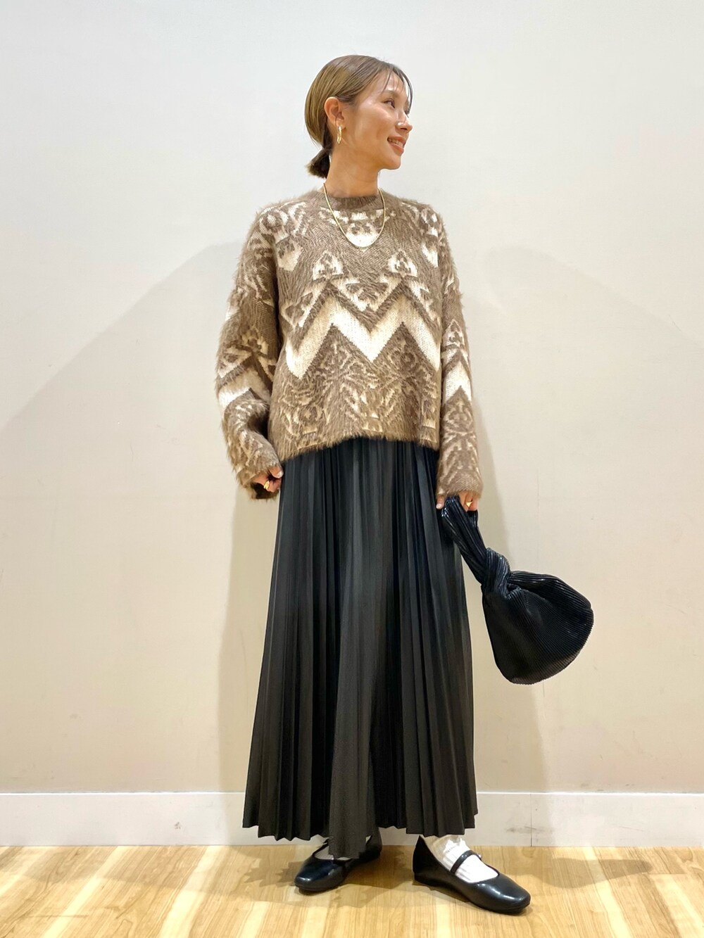 ベージュ系のカーディガン/ボレロ、ブラウン系のニット/セーター、ブラック系のスカートを着用したレディースの冬コーディネートの5枚目の写真