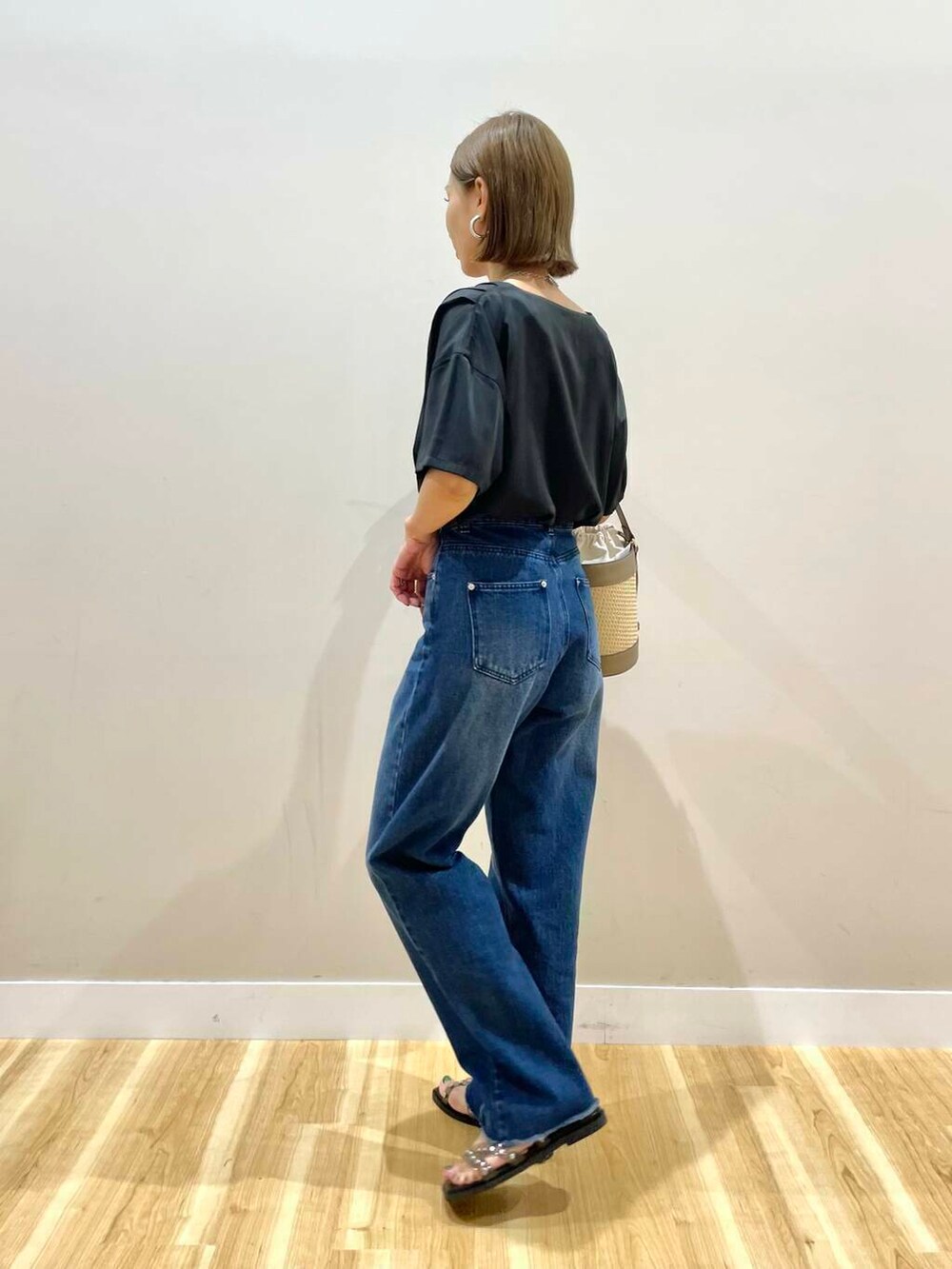 グレー系のショルダーバッグ、ブラック系のサンダル、ブルー系のデニムパンツを着用したレディースの夏コーディネートの4枚目の写真