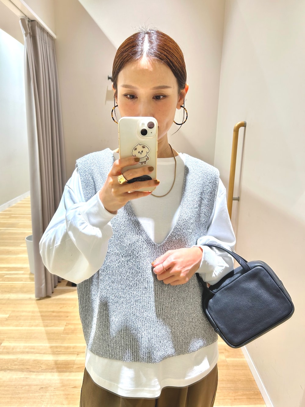 グレー系のベスト、ブラウン系のその他パンツ、ブラック系のボストンバッグを着用したレディースの冬コーディネートの4枚目の写真