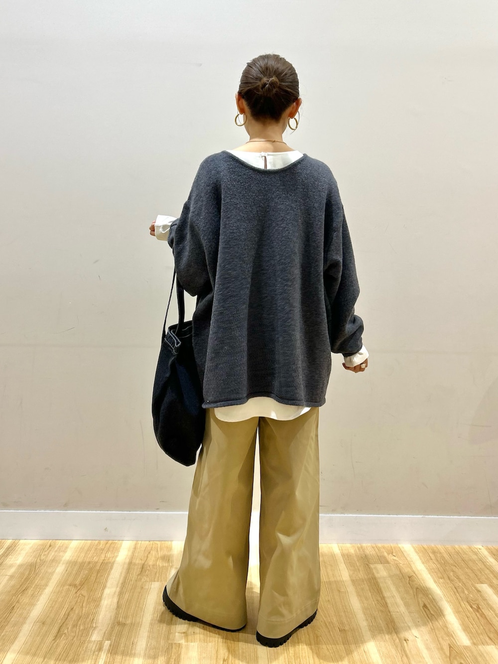グレー系のニット/セーター、ホワイト系のシャツ/ブラウス、ベージュ系のその他パンツを着用したレディースの秋コーディネートの3枚目の写真