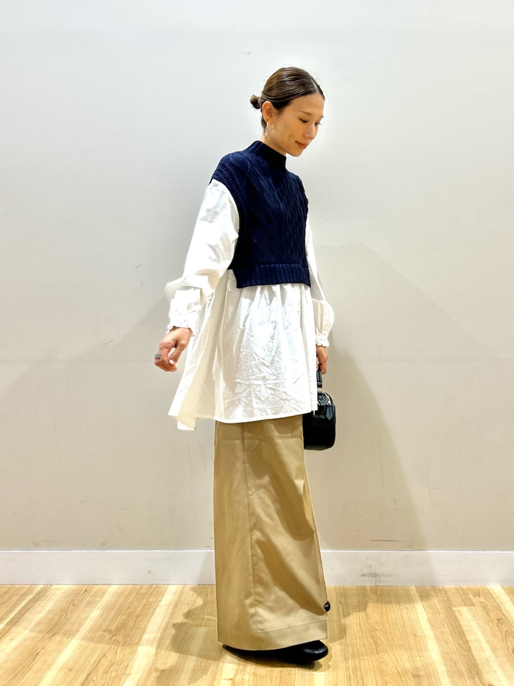 ホワイト系のシャツ/ブラウス、ベージュ系のチノパンツ、ブラック系のショルダーバッグを着用したレディースの秋コーディネートの2枚目の写真