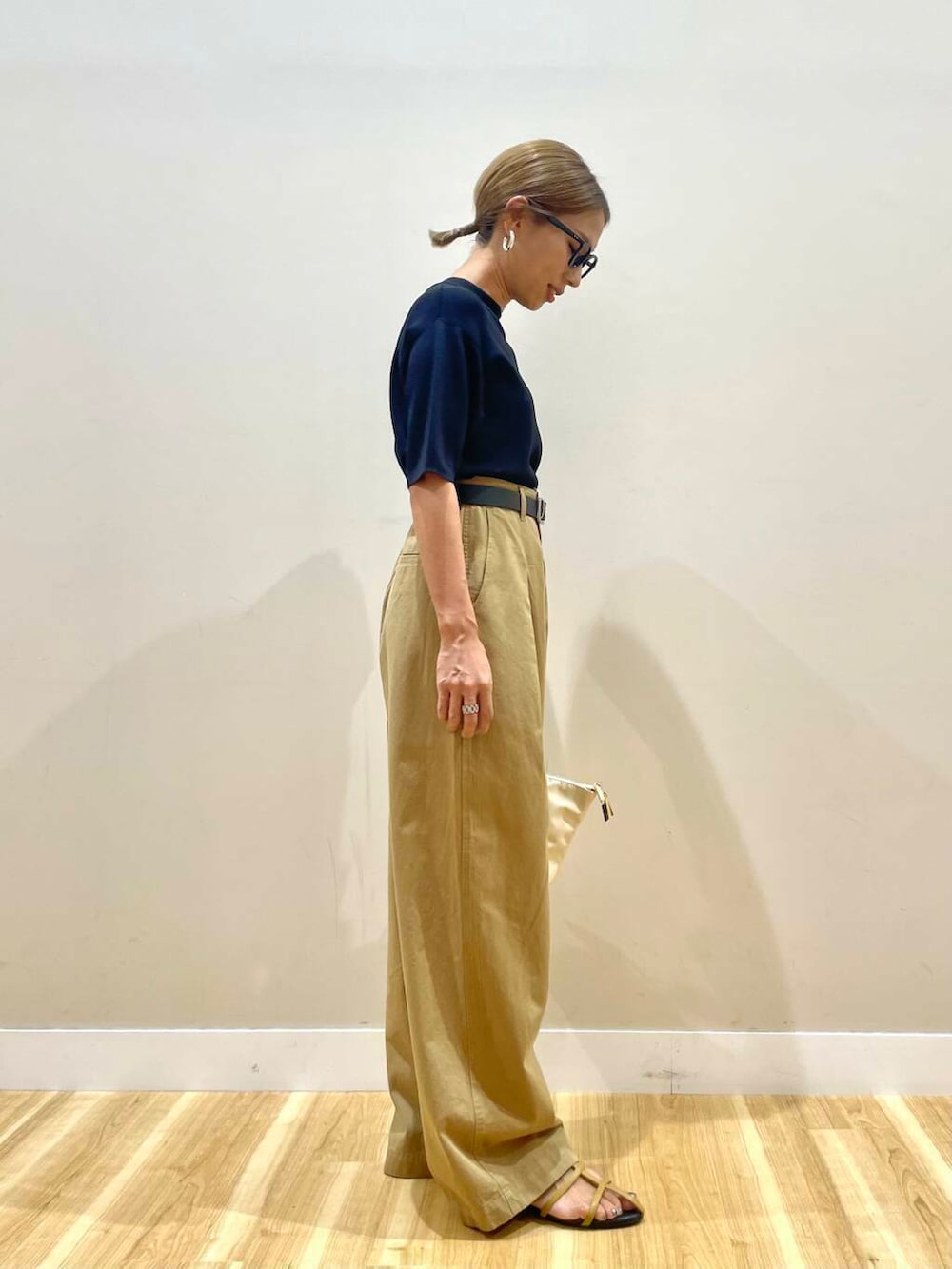 ブラウン系のサンダル、ブラック系のニット/セーター、ホワイト系のトートバッグを着用したレディースの夏コーディネートの2枚目の写真