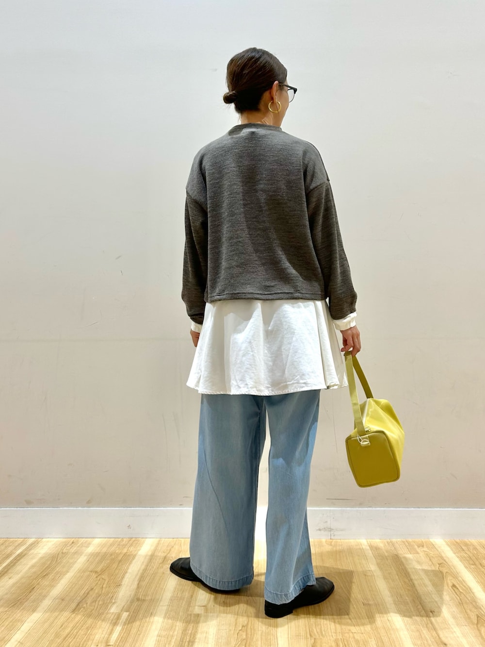 ブラウン系のシャツ/ブラウス、ブルー系のその他パンツ、イエロー系のトートバッグを着用したレディースの春コーディネートの3枚目の写真