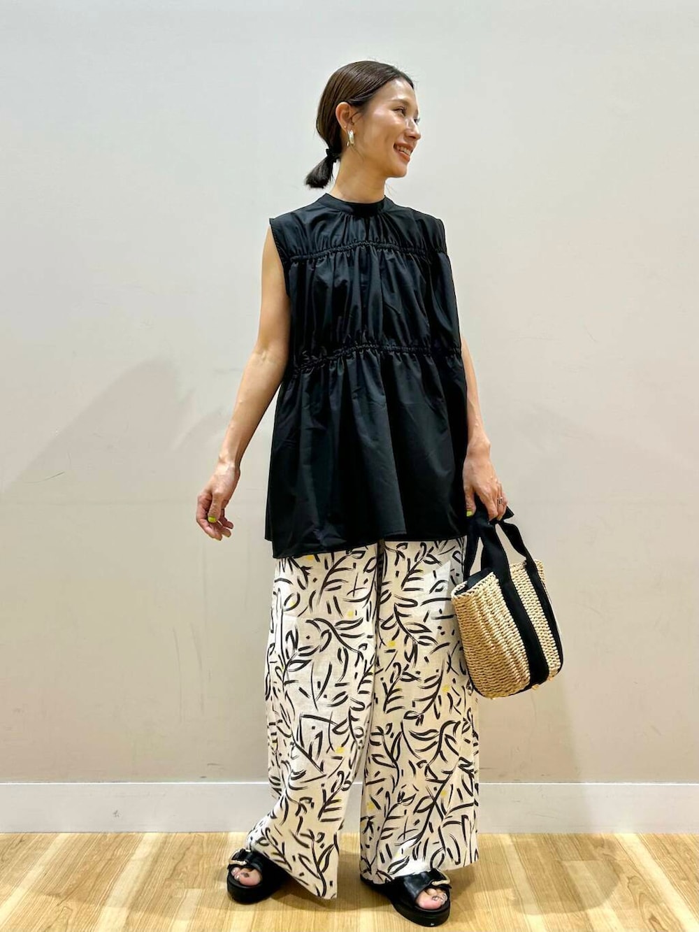 ホワイト系のその他パンツ、ベージュ系のハンドバッグ、ブラック系のサンダルを着用したレディースの夏コーディネートの5枚目の写真