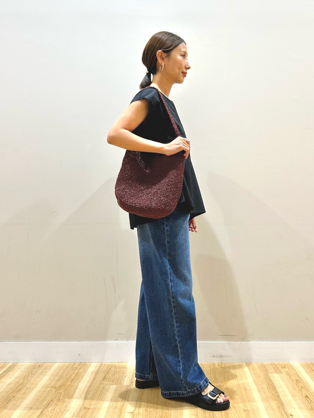 ブラック系のシャツ/ブラウス、ブルー系のデニムパンツを着用したレディースの秋コーディネートの4枚目の写真