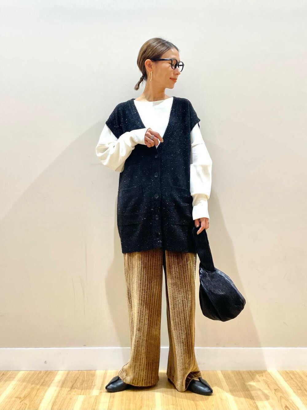 ブラック系のハンドバッグ、ホワイト系のTシャツ/カットソー、ブラウン系のその他パンツを着用したレディースの秋コーディネートの2枚目の写真