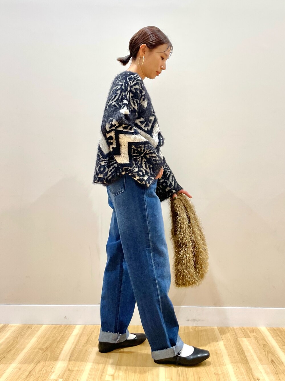 グレー系のその他アウター、ブラック系のニット/セーター、ブルー系のデニムパンツを着用したレディースの冬コーディネートの10枚目の写真