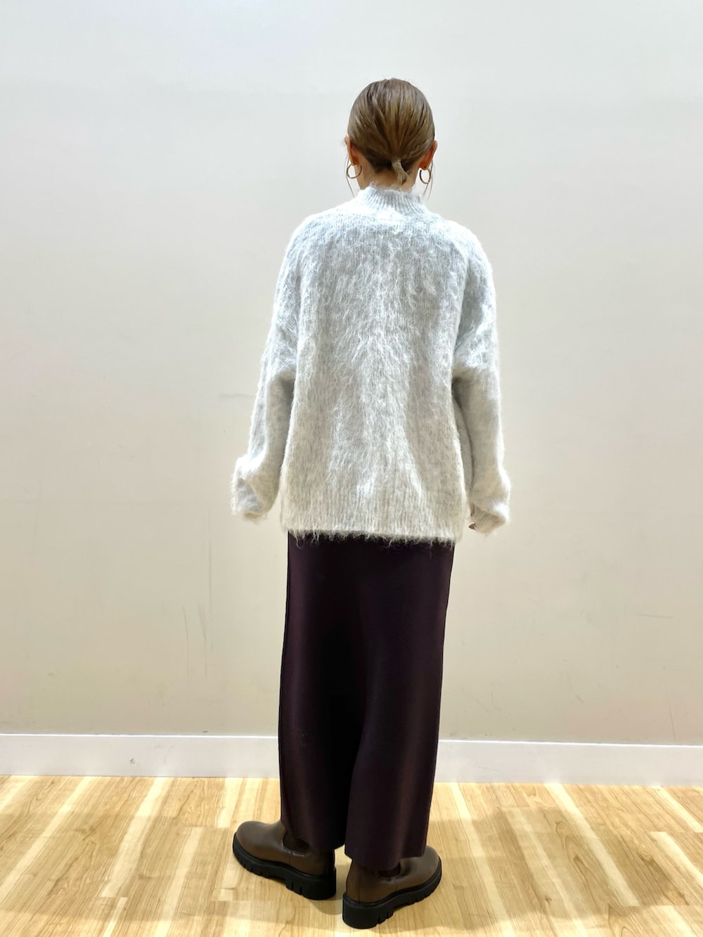 ホワイト系のダウンジャケット/コート、グレー系のニット/セーター、ブラウン系のスカートを着用したレディースの冬コーディネートの8枚目の写真