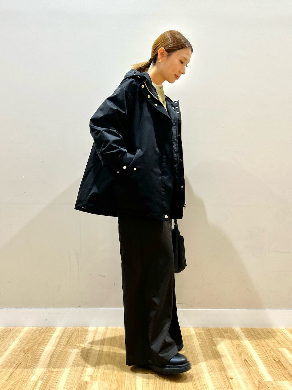 ブラック系のダウンジャケット/コート、グリーン系のカーディガン/ボレロ、ブラウン系のその他パンツを着用したレディースの秋コーディネートの4枚目の写真