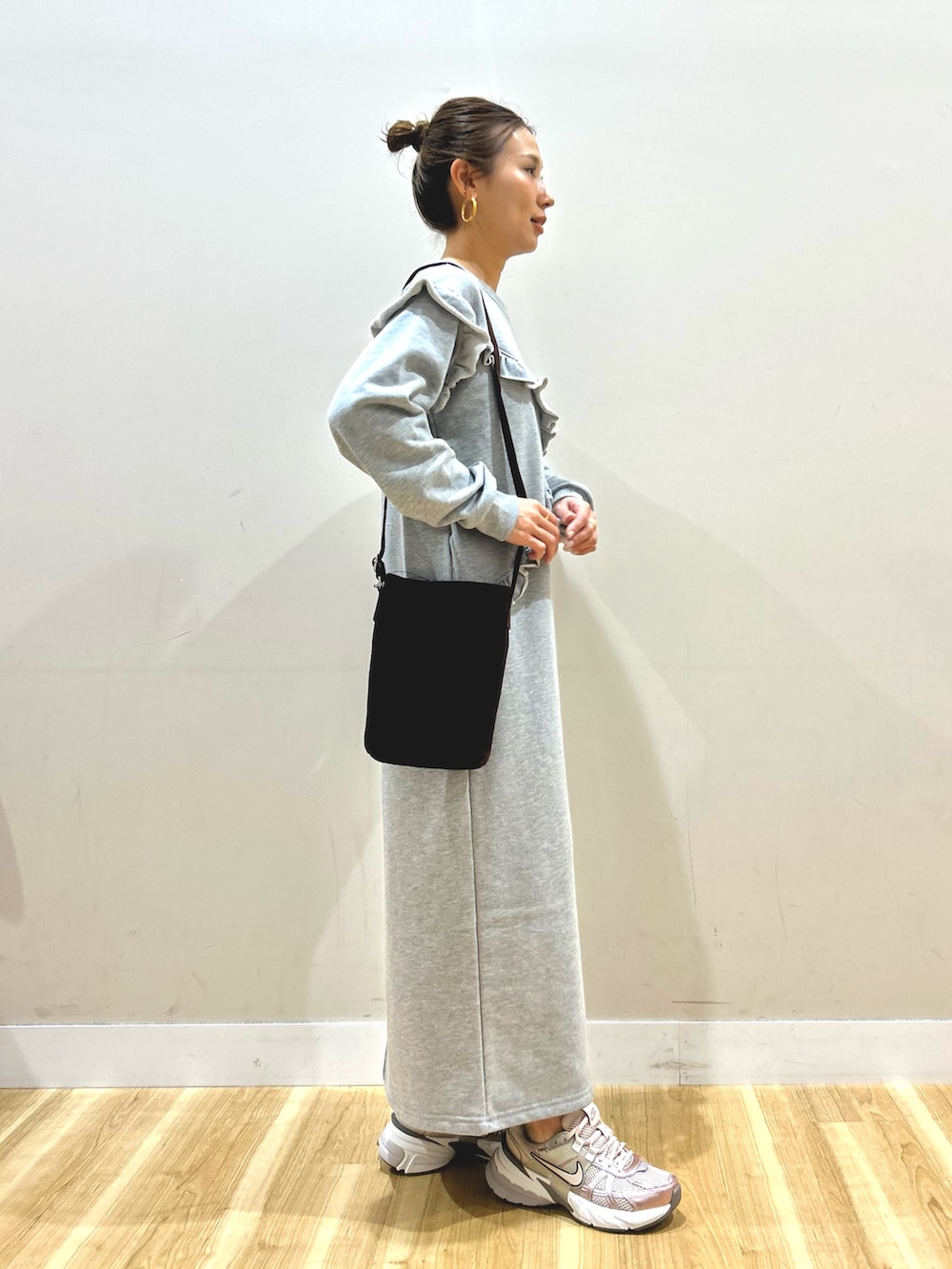 グリーン系のモッズコート、グレー系のワンピース、ブラウン系のショルダーバッグを着用したレディースの春コーディネートの5枚目の写真