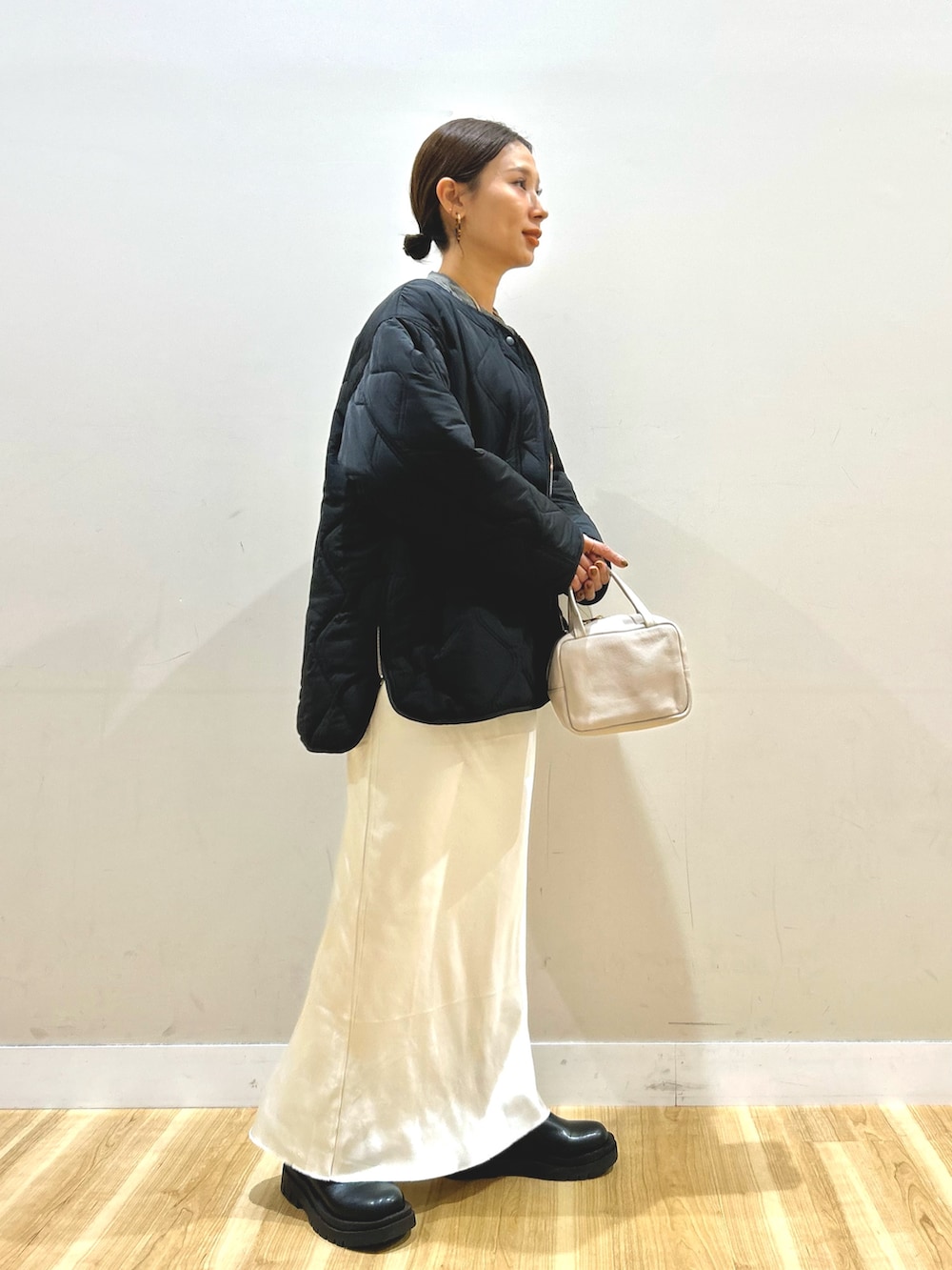 ブラック系のブルゾン、ホワイト系のスカート、グレー系のボストンバッグを着用したレディースの冬コーディネートの2枚目の写真