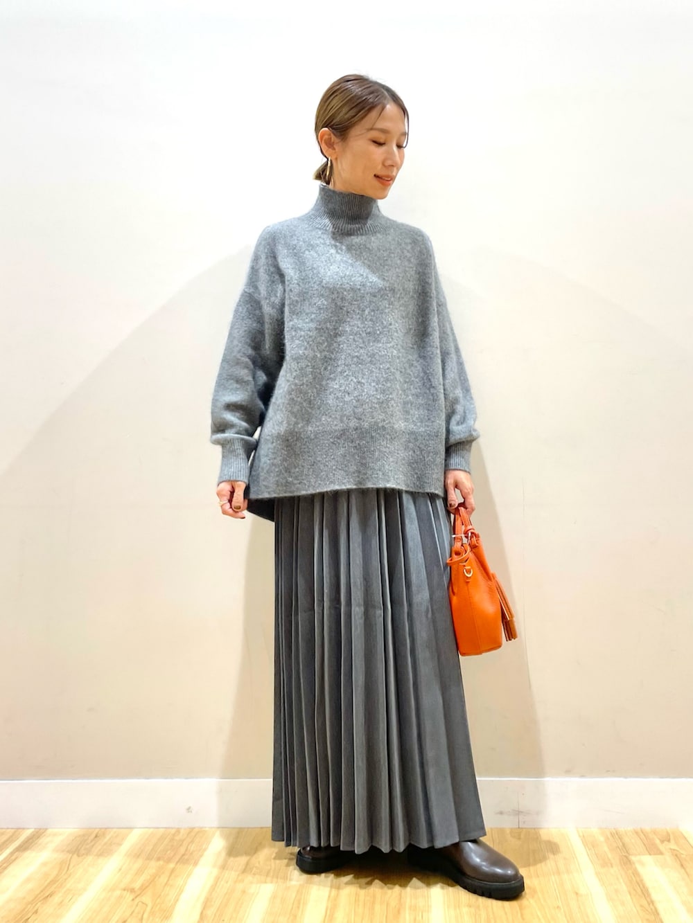 ホワイト系のダウンジャケット/コート、グレー系のニット/セーター、グレー系のスカートを着用したレディースの冬コーディネートの2枚目の写真