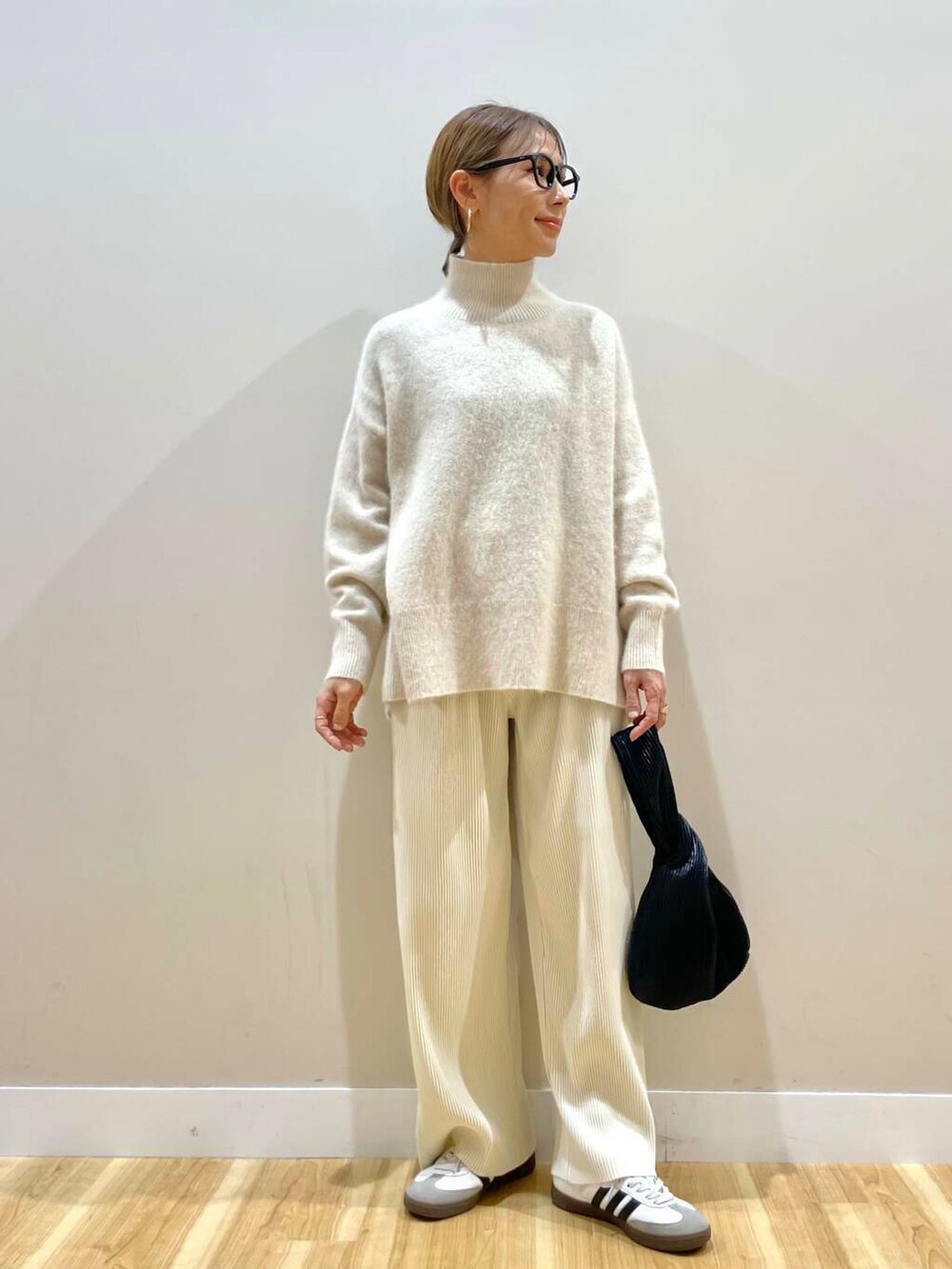 ホワイト系のその他パンツ、ブラック系のハンドバッグ、グリーン系のその他アウターを着用したレディースの冬コーディネートの8枚目の写真