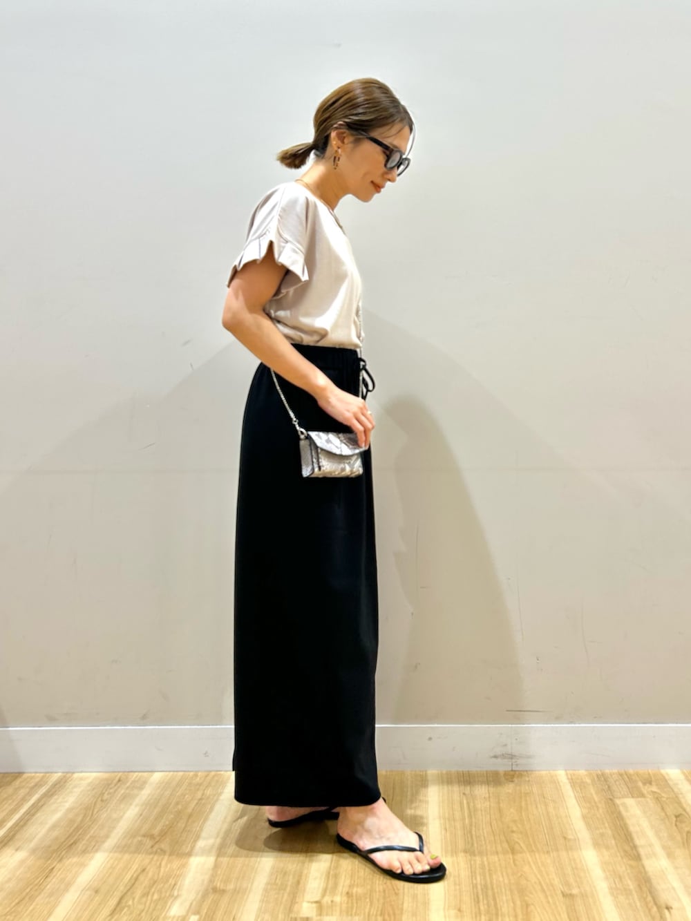 ベージュ系のTシャツ/カットソー、ブラック系のスカート、その他のショルダーバッグを着用したレディースの夏コーディネートの4枚目の写真