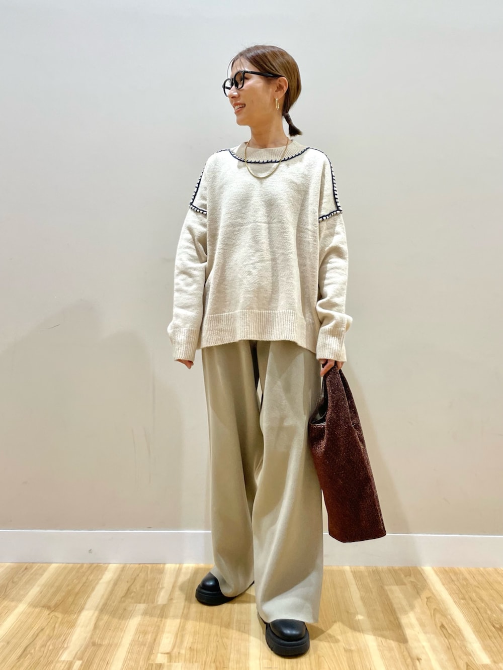 ブラック系のダウンジャケット/コート、ホワイト系のニット/セーター、ベージュ系のその他パンツを着用したレディースの冬コーディネートの5枚目の写真