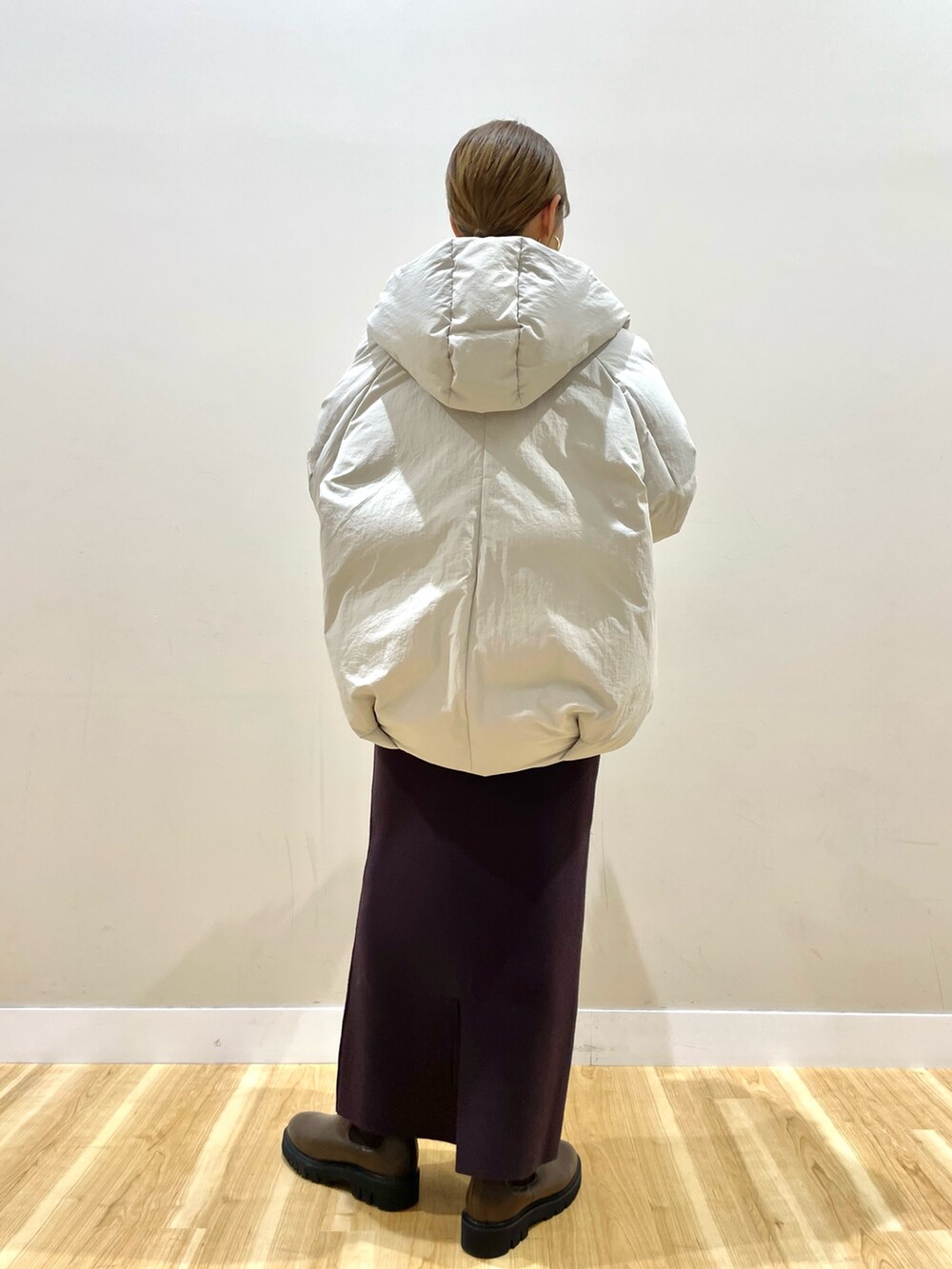 ホワイト系のダウンジャケット/コート、グレー系のニット/セーター、ブラウン系のスカートを着用したレディースの冬コーディネートの4枚目の写真