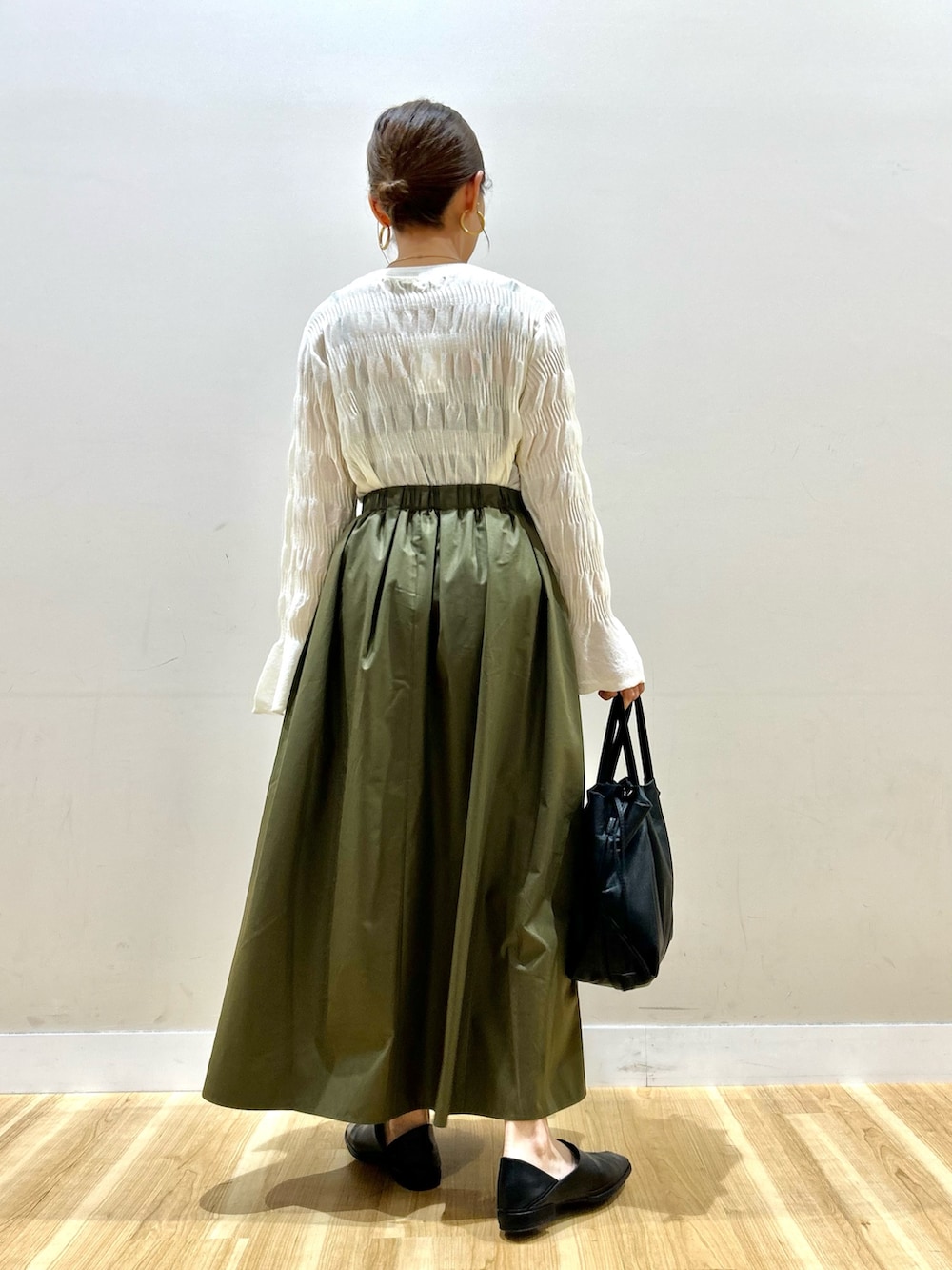 ホワイト系のカーディガン/ボレロ、ホワイト系のニット/セーター、グリーン系のスカートを着用したレディースの春コーディネートの6枚目の写真