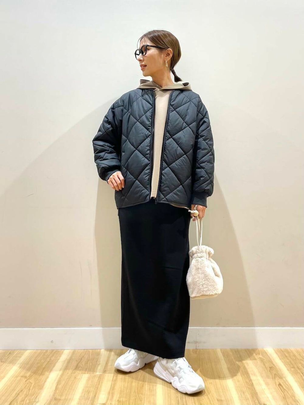 ホワイト系のスニーカー、ホワイト系のショルダーバッグ、ブラウン系のワンピースを着用したレディースの冬コーディネートの2枚目の写真