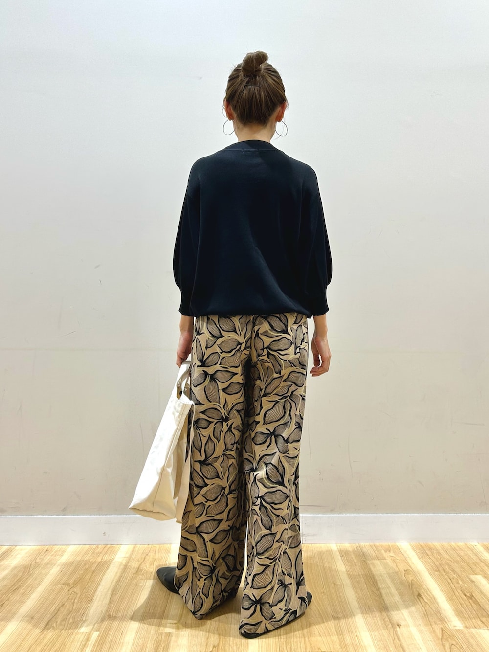 ブラック系のマウンテンパーカー、ブラック系のニット/セーター、ブラウン系のその他パンツを着用したレディースの春コーディネートの5枚目の写真