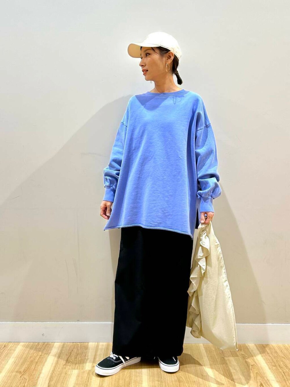 ブラック系のスニーカー、ホワイト系のトートバッグ、ブラック系のデニムジャケットを着用したレディースの春コーディネートの3枚目の写真