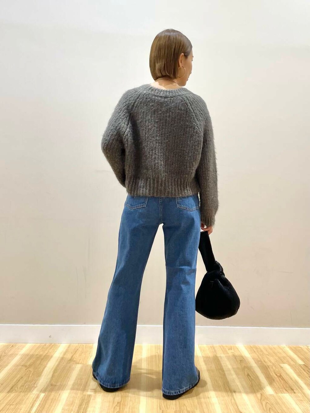 ブラウン系のブーツ、ブルー系のデニムパンツ、ブラック系のハンドバッグを着用したレディースの秋コーディネートの8枚目の写真