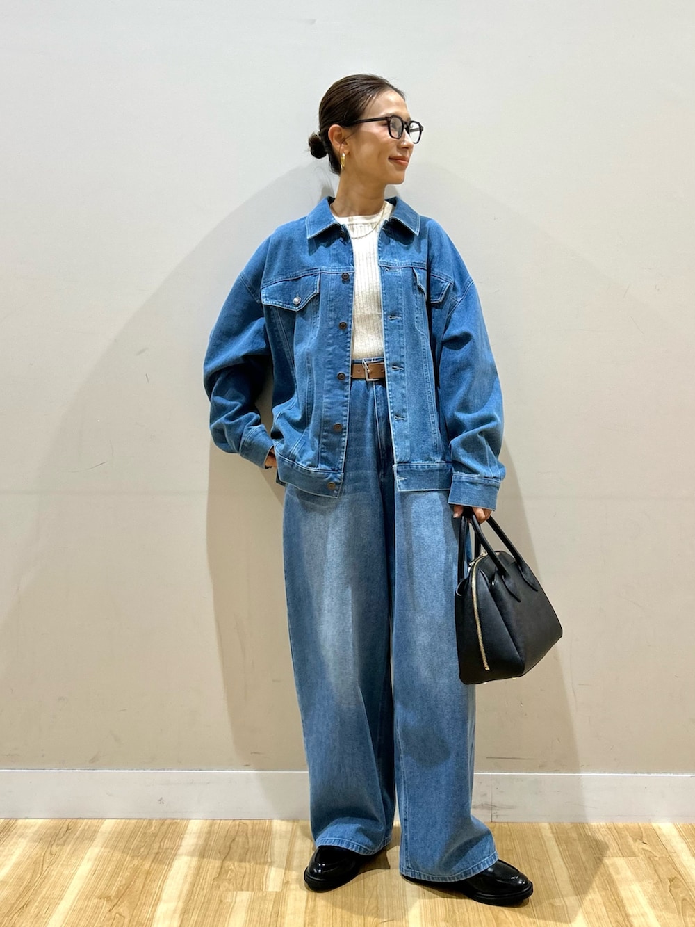 ブルー系のカバーオール、ブルー系のその他パンツ、ブラウン系のダウンベストを着用したレディースの秋コーディネートの6枚目の写真