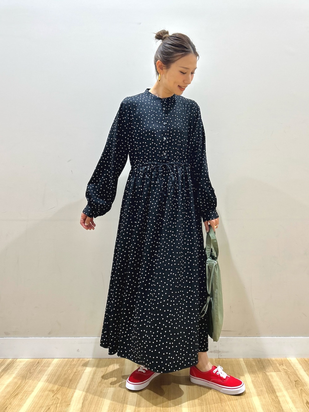 ホワイト系のマウンテンパーカー、ブラック系のワンピース、グリーン系のショルダーバッグを着用したレディースの春コーディネートの6枚目の写真