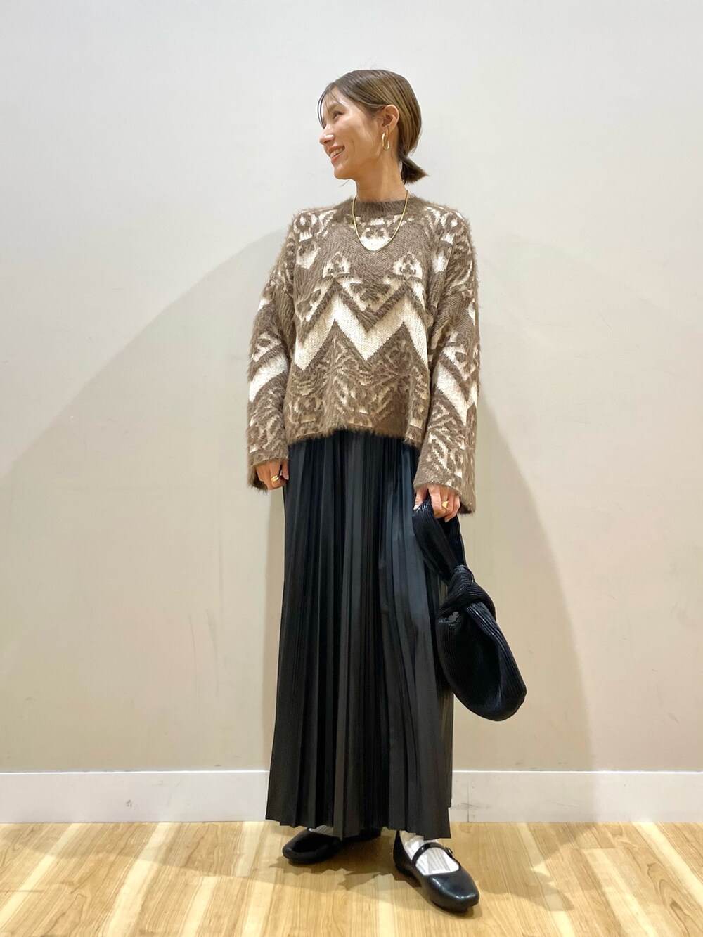 ベージュ系のカーディガン/ボレロ、ブラウン系のニット/セーター、ブラック系のスカートを着用したレディースの冬コーディネートの2枚目の写真