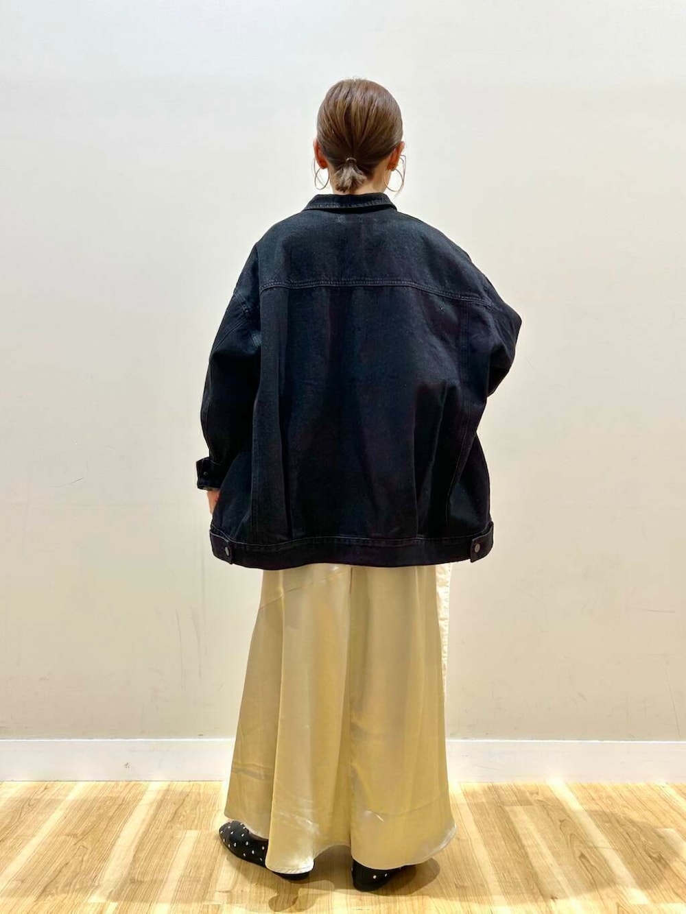 ブラック系のパンプス、ホワイト系のトートバッグ、ブラック系のデニムジャケットを着用したレディースの冬コーディネートの3枚目の写真