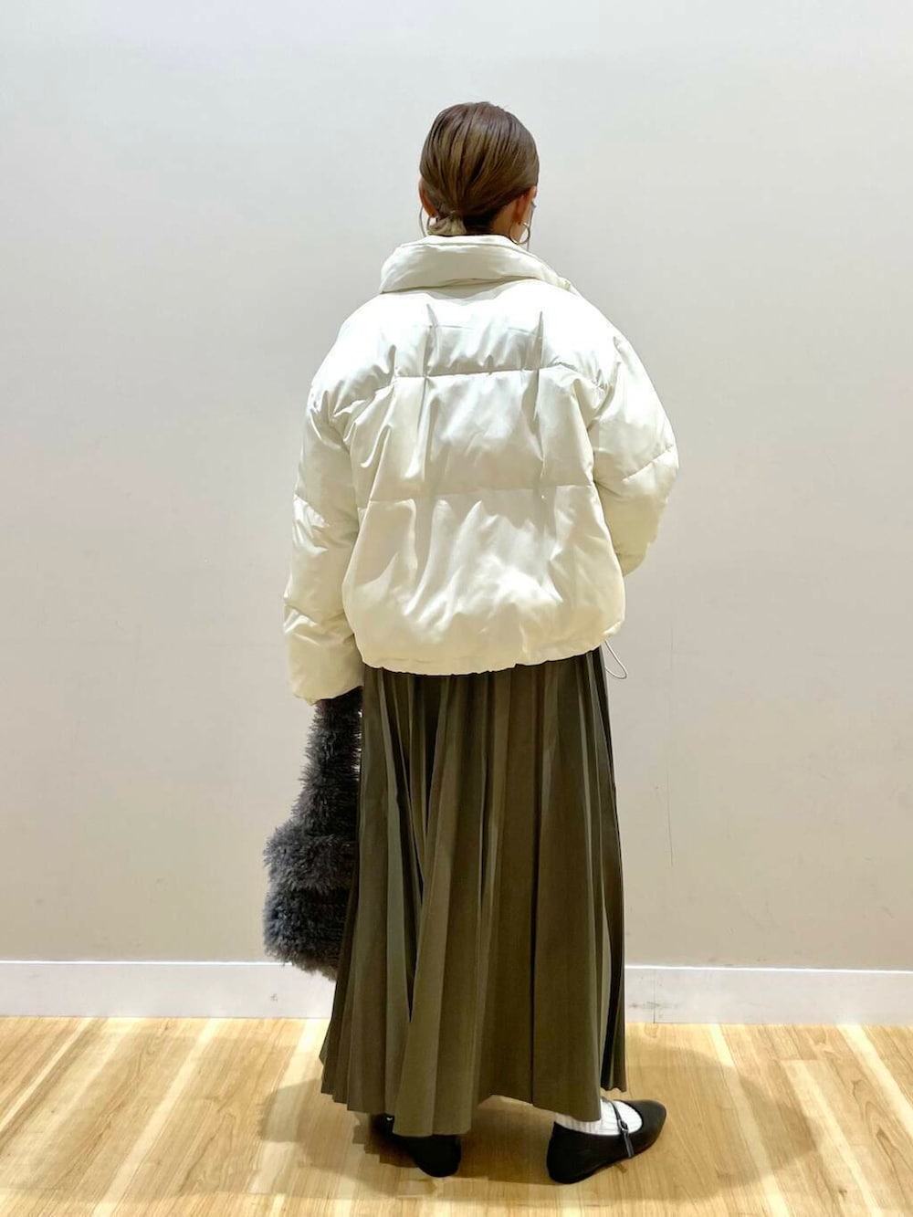 ブラック系のパンプス、グリーン系のスカート、グレー系のハンドバッグを着用したレディースの冬コーディネートの5枚目の写真