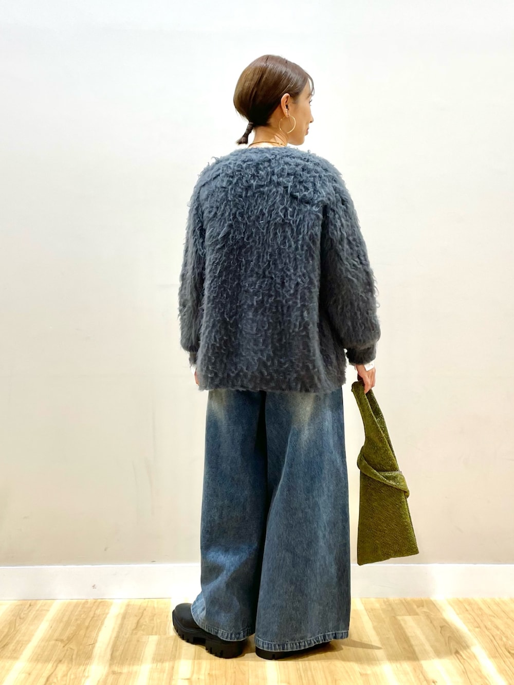 グレー系のカーディガン/ボレロ、ホワイト系のTシャツ/カットソー、ブルー系のデニムパンツを着用したレディースの冬コーディネートの3枚目の写真