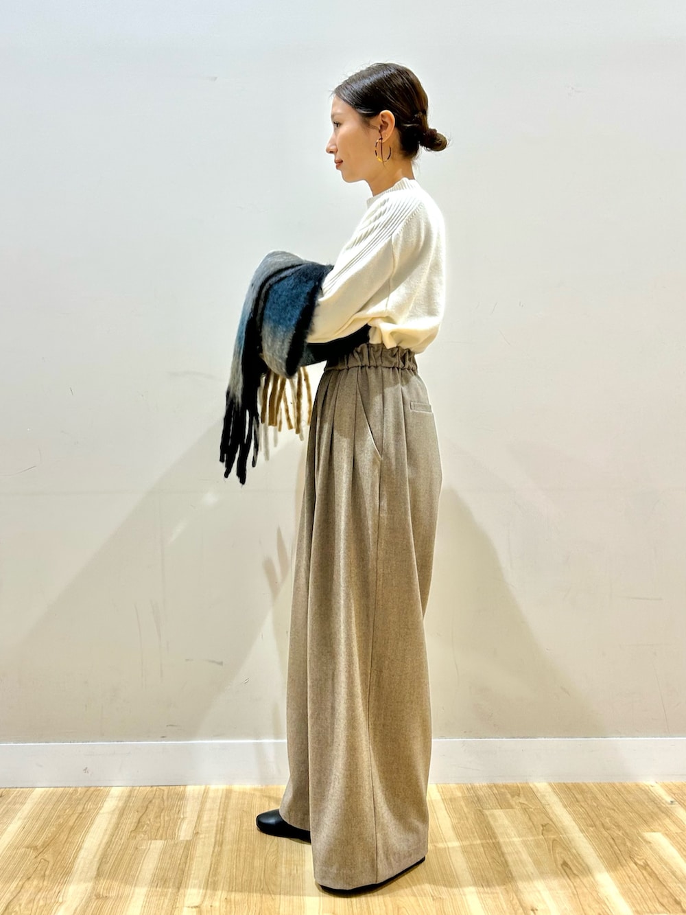 ベージュ系のその他パンツ、ブラック系のその他アウター、ホワイト系のニット/セーターを着用したレディースの冬コーディネートの6枚目の写真