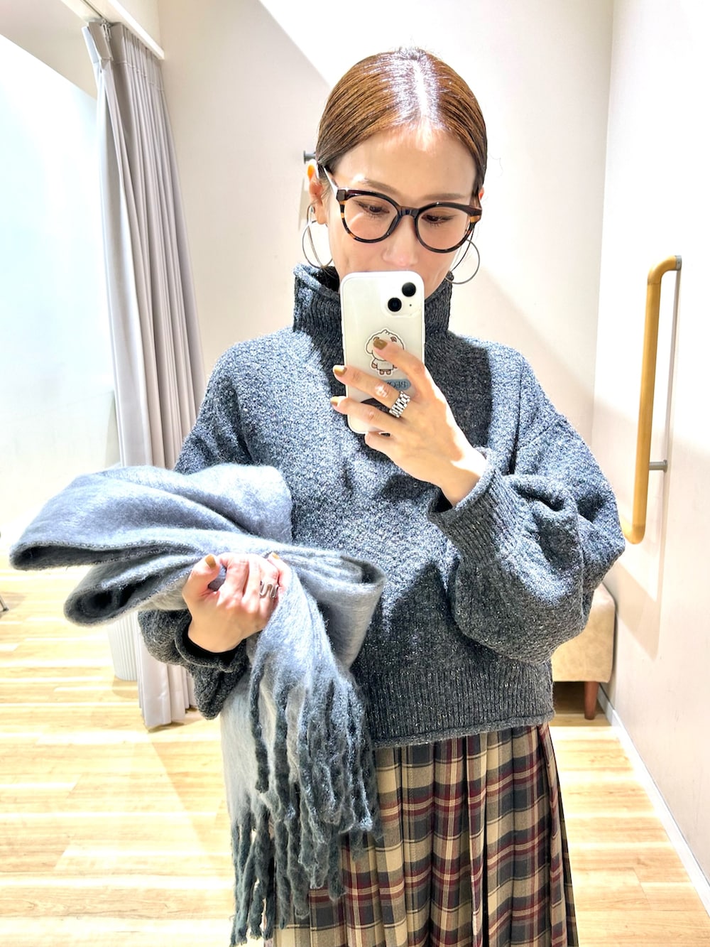 グレー系のニット/セーター、ブラウン系のスカート、ブラック系のブーツを着用したレディースの冬コーディネートの4枚目の写真