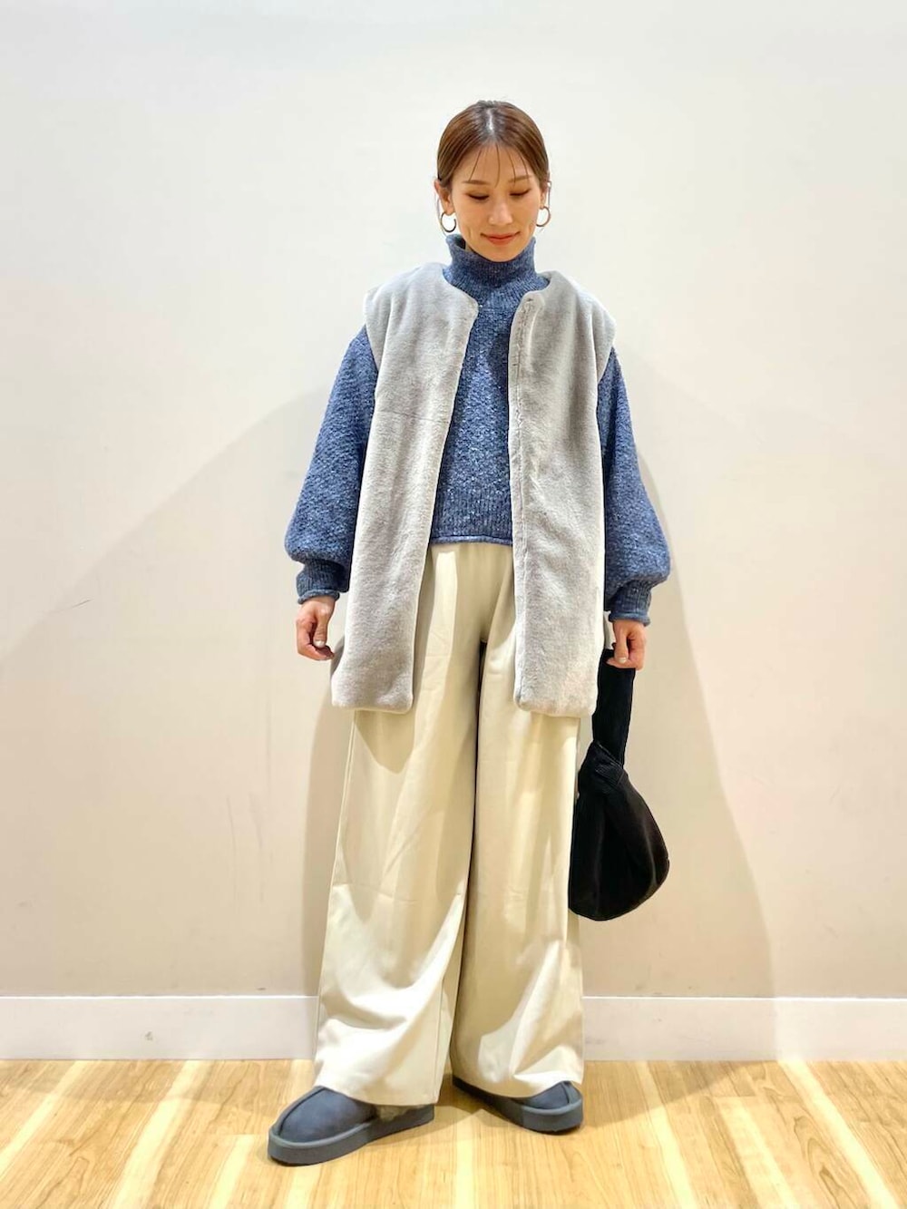 ブラック系のハンドバッグ、グレー系のその他アウター、グレー系のその他シューズを着用したレディースの冬コーディネートの2枚目の写真