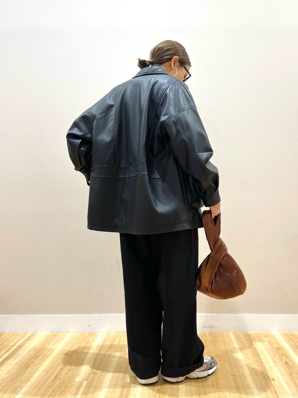 ブラック系のその他アウター、ホワイト系のニット/セーター、ブラック系のチノパンツを着用したレディースの秋コーディネートの3枚目の写真