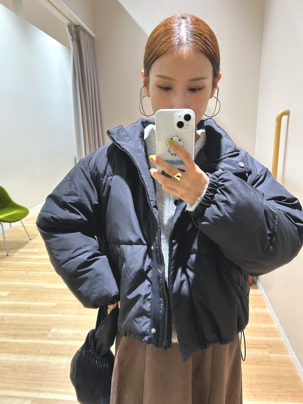 ブラック系のダウンジャケット/コート、グレー系のニット/セーター、ブラウン系のスカートを着用したレディースの秋コーディネートの7枚目の写真