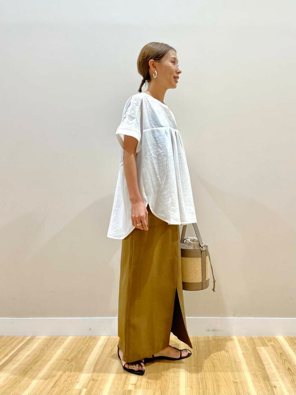 ホワイト系のシャツ/ブラウス、グレー系のショルダーバッグ、イエロー系のスカートを着用したレディースの夏コーディネートの2枚目の写真