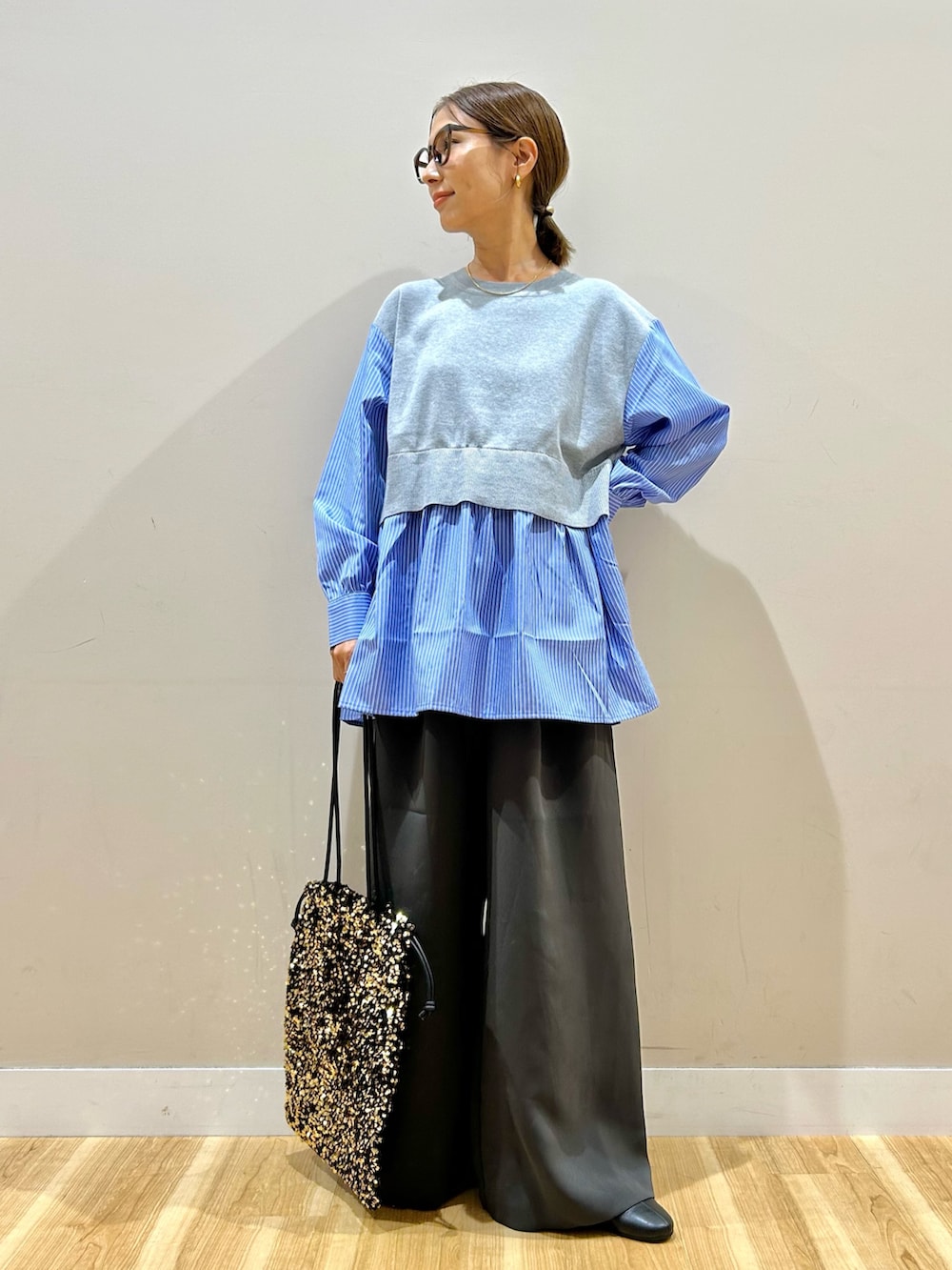 グレー系のニット/セーター、グレー系のその他パンツ、ゴールド系のトートバッグを着用したレディースの秋コーディネートの4枚目の写真