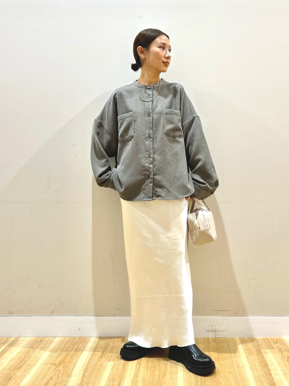 ブラック系のブルゾン、ホワイト系のスカート、グレー系のボストンバッグを着用したレディースの冬コーディネートの4枚目の写真