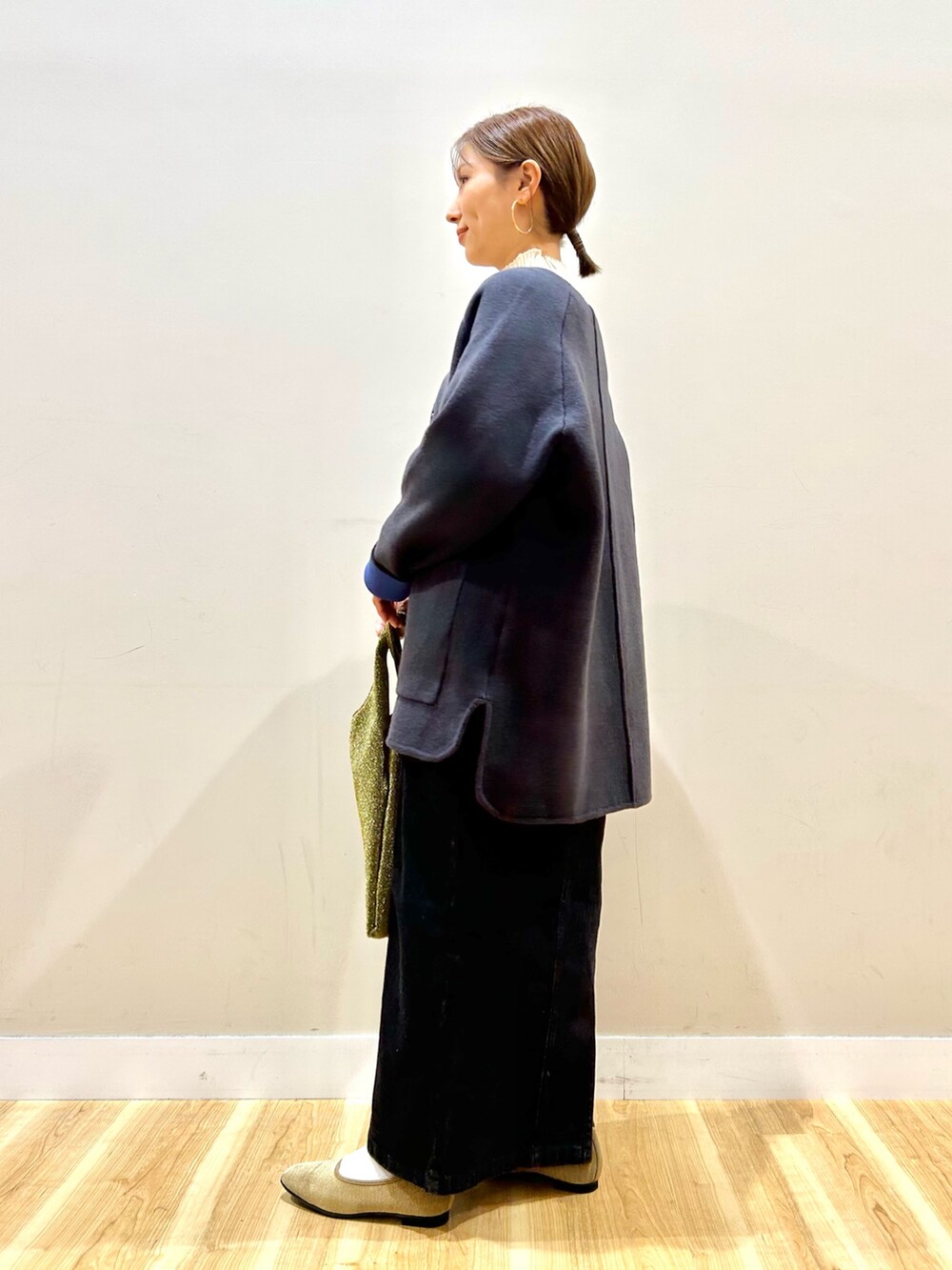 グレー系のカーディガン/ボレロ、ホワイト系のニット/セーター、ブラック系のワンピースを着用したレディースの冬コーディネートの2枚目の写真