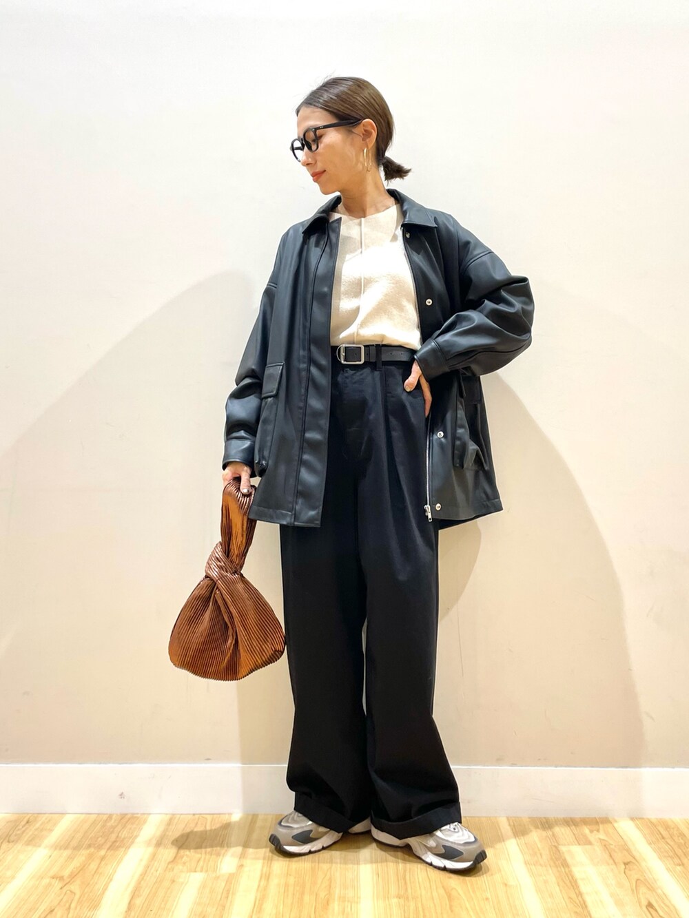 ブラック系のその他アウター、ホワイト系のニット/セーター、ブラック系のチノパンツを着用したレディースの秋コーディネートの5枚目の写真