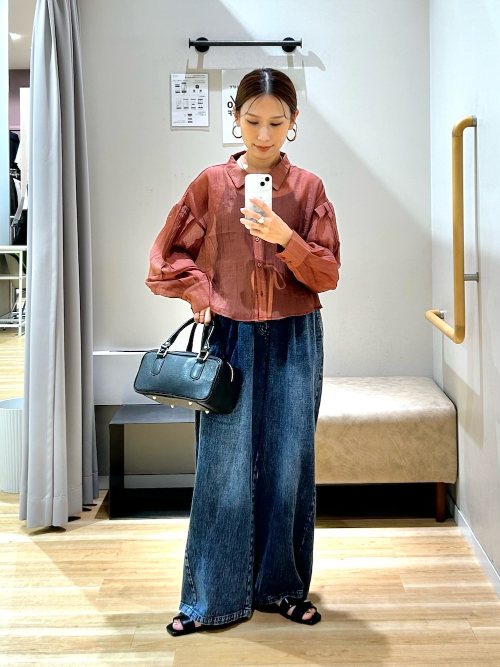 オレンジ系のシャツ/ブラウス、ブルー系のデニムパンツ、ブラック系のハンドバッグを着用したレディースの夏コーディネートの4枚目の写真