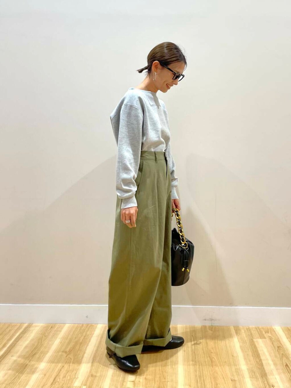 ブラック系のパンプス、ブラック系のショルダーバッグ、グレー系のニット/セーターを着用したレディースの秋コーディネートの2枚目の写真