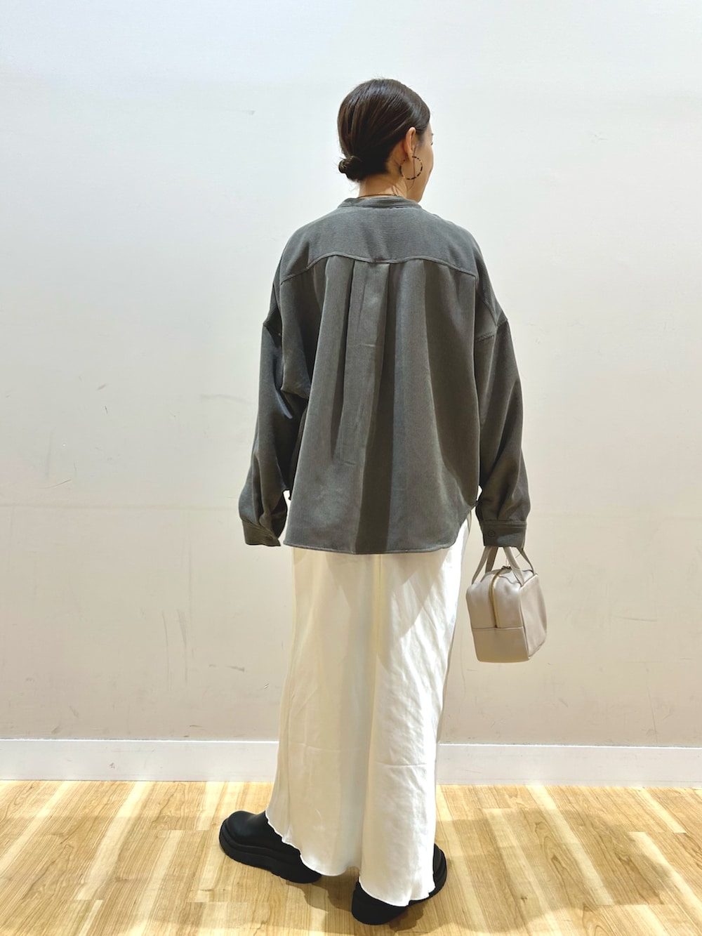 ブラック系のブルゾン、ホワイト系のスカート、グレー系のボストンバッグを着用したレディースの冬コーディネートの6枚目の写真