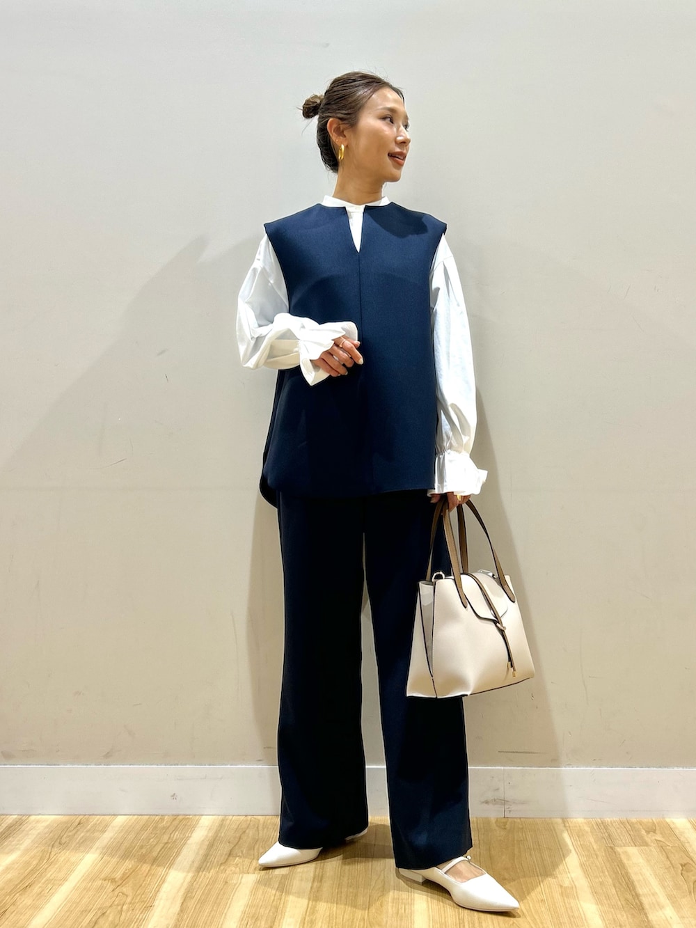 ブルー系のセットアップ、ホワイト系のシャツ/ブラウス、ベージュ系のトートバッグを着用したレディースの春コーディネートの4枚目の写真
