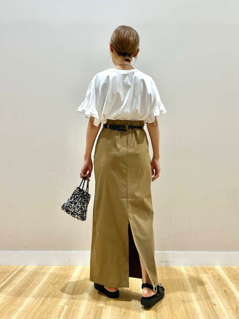 シルバー系のショルダーバッグ、ブラック系のサンダル、ホワイト系のTシャツ/カットソーを着用したレディースの春コーディネートの4枚目の写真