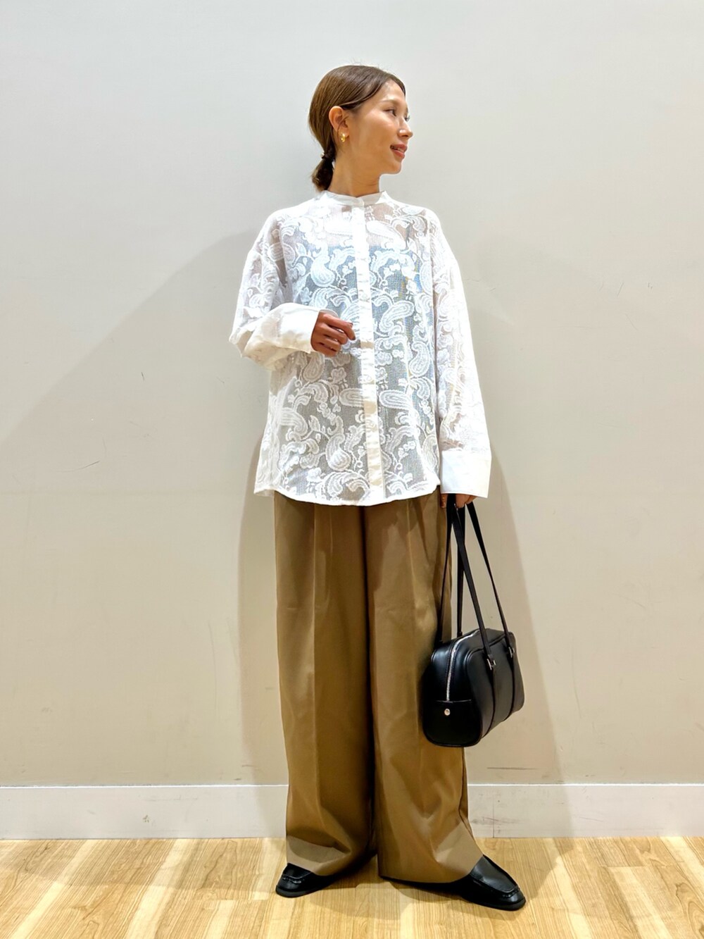 ブラウン系のその他パンツ、ブラック系のボストンバッグ、ホワイト系のシャツ/ブラウスを着用したレディースの秋コーディネートの4枚目の写真