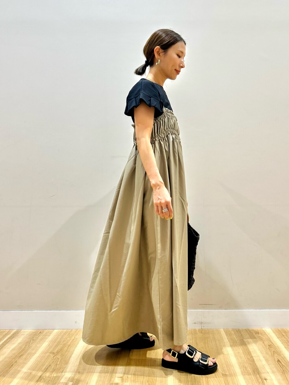 ブラック系のTシャツ/カットソー、ベージュ系のワンピースを着用したレディースの夏コーディネートの2枚目の写真