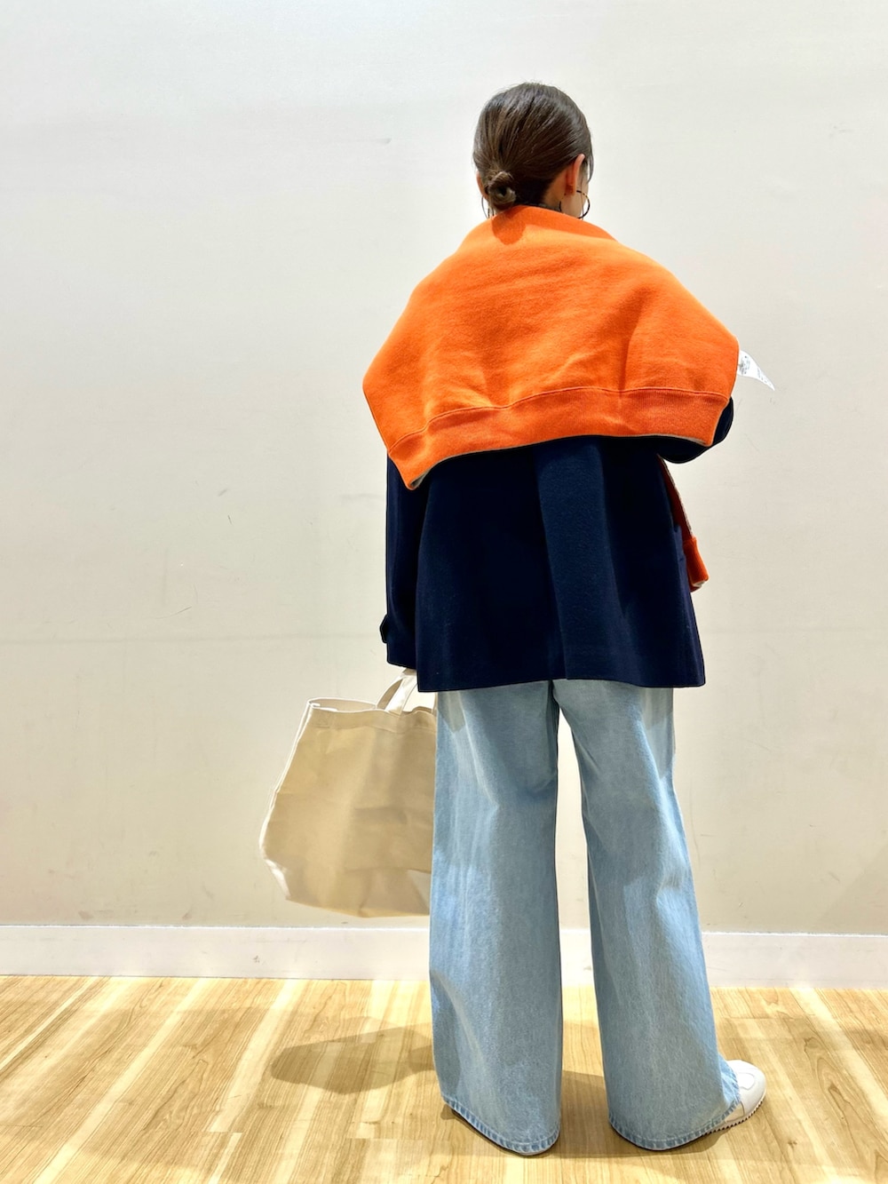 ブルー系のピーコート、グレー系のニット/セーター、オレンジ系のニット/セーターを着用したレディースの冬コーディネートの3枚目の写真