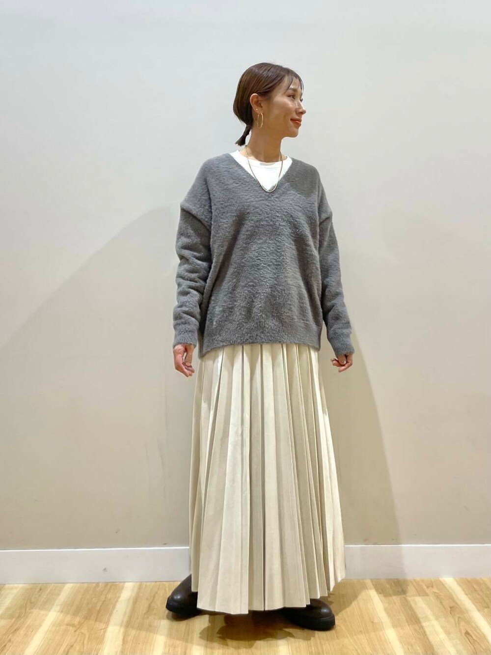 ベージュ系のスカート、ブラック系のブーツ、グレー系のダウンジャケット/コートを着用したレディースの冬コーディネートの10枚目の写真